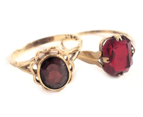 Two dress rings, comprising a garnet cluster ring with petalated border on V splayed shoulders, yellow metal stamped 9ct, rin