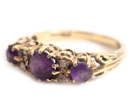 A 9ct gold amethyst set gypsy ring, set with three oval graduated amethysts and four tiny diamonds, in a raised claw basket s