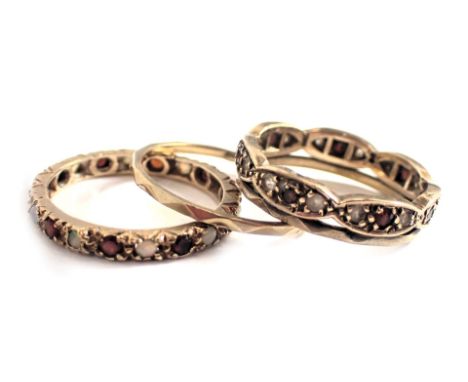 Two eternity rings, comprising a 9ct gold CZ and garnet set eternity ring, ring size R, and an opal and garnet eternity ring,