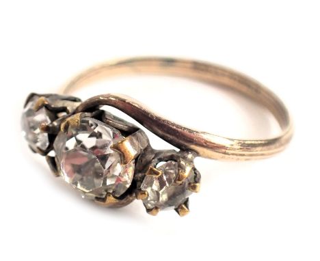 A three stone dress ring, set with three paste stones, each in twist claw setting, on a rolled gold band, ring size K½, 1.6g 