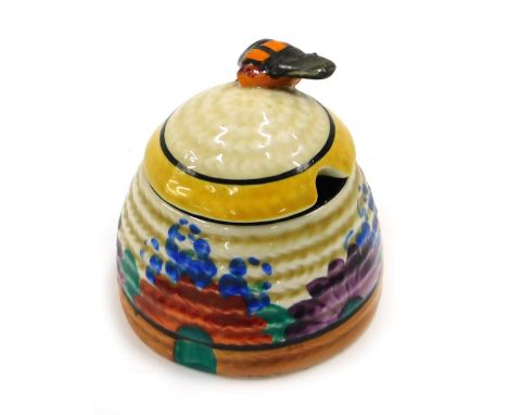 A Clarice Cliff Bizarre honey jar and cover, decorated with the Gay Day pattern, 7cm high. 