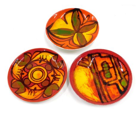 Three Poole pottery Delphis style shallow dishes or plates, each decorated in shades of red, green, orange and yellow, printe