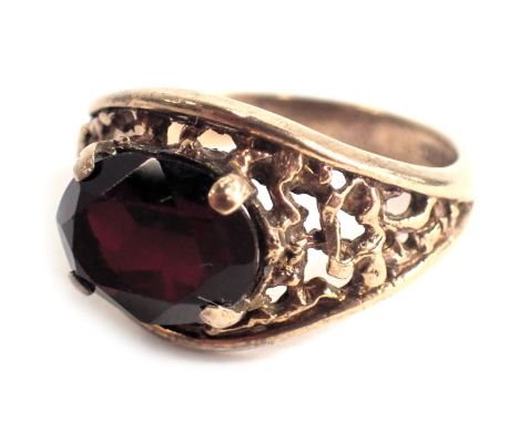 A 9ct gold garnet dress ring, with oval cut garnet in four claw setting, with bark effect shoulders, ring size N, 3.9g all in