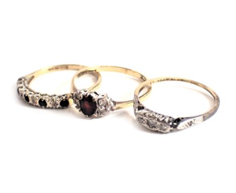 Three dress rings, comprising a CZ and garnet set dress ring, yellow metal stamped 9ct, ring size P, a 9ct gold sapphire and 