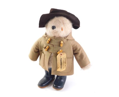 A plush model of Paddington Bear, with brown duffel coat, hat, Dunlop wellies, and label, 49cm high. 