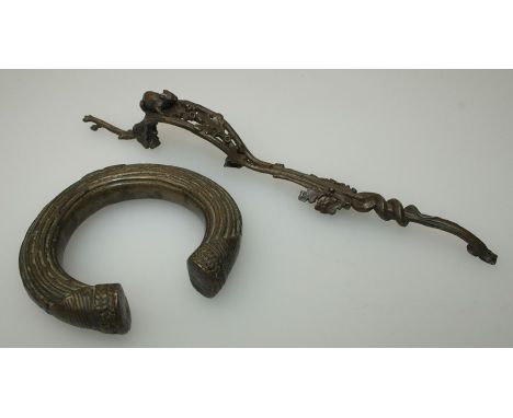 An ornate bronze coloured metal trigger guard, cast with field mouse and oak leaves, 29cm and a bronze 'slave' type bangle
