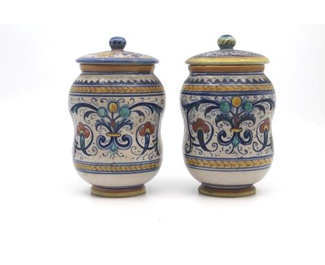 A pair of small Deruta maiolica albarello and covers, circa 1930, of typically waisted form and decorated with polychrome scr
