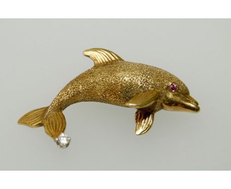A gold brooch, fashioned as a dolphin with claw set diamond to tail fin and ruby eye. Stamped 18k. 3.5cm, 8gm gross weight&nb