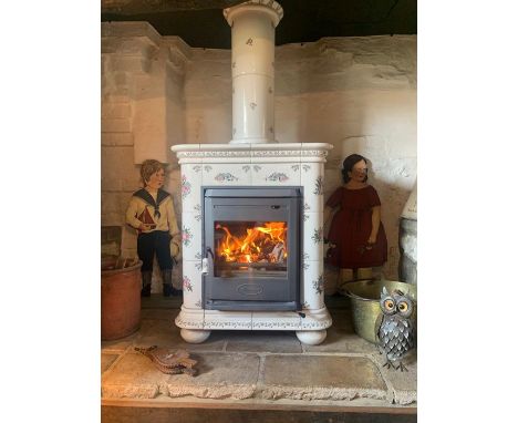 A Dovre woodburning stove with hand painted French floral ceramic tile surround and chimney piece, raised on bun feet, 161 x 