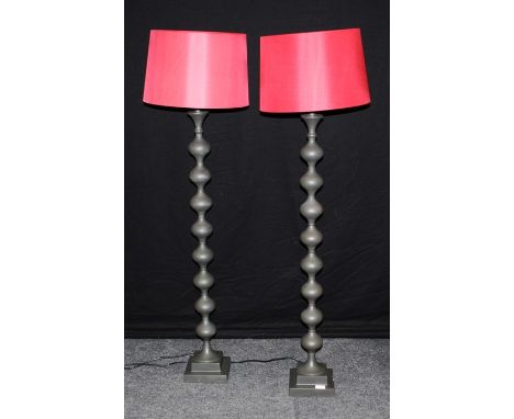 A pair of contempary black metal stand floor lamps, the bodies of bobbin turned form, height 142cm including shades