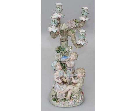 Ernst Bohne and Sohne, a late 19th century Continental porcelain figural four sconce table candlestick, modelled with three c