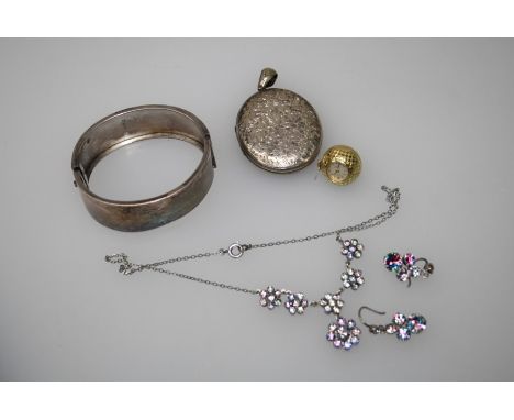 A Victorian silver hinged bangle with raised band to the front engraved and set pearls and cushion cut red stone, Birmingham 