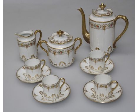 A Limoges part coffee set, the parcel gilt ivory ground decorated with sprigs of flowers. 4 cups, 4 saucers, a coffee pot and