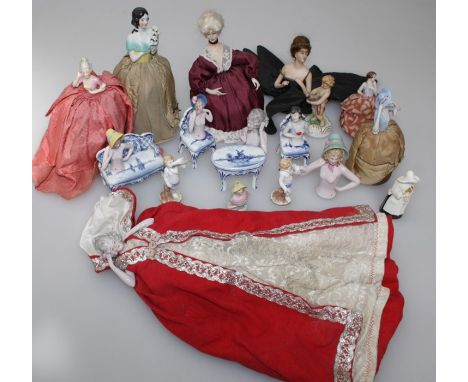 A collection of thirteen early 20th century and later ceramic 'pin cushion' dolls, together with a four piece suite of German