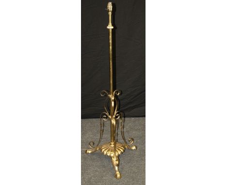 An early 20th century brass telescopic standard lamp with plaited cream silk shade, on lobed base and stepped hoof feet