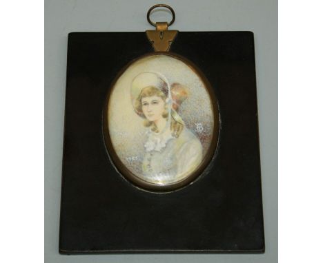 20th century European school, a half length portrait miniature of a young woman wearing ribbon tied bonnet. Oil on ivorine pa