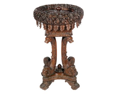 A late 19th  to early 20th Century Anglo Indian carved padoukwood jardiniere stand, the lift off cover revealing a zinc and c