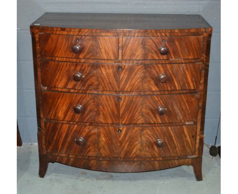 A George III mahogany bow front chest of two short and three long drawers flanked by canted sides and fitted with turned wood