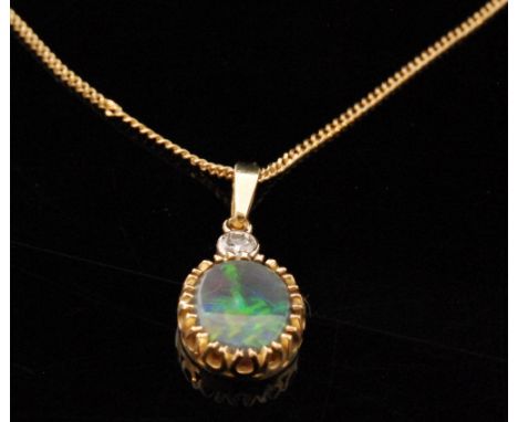 An 18ct opal and diamond pendant, the oval opal claw set below collar set brilliant cut diamond pendant bale and fine trace l