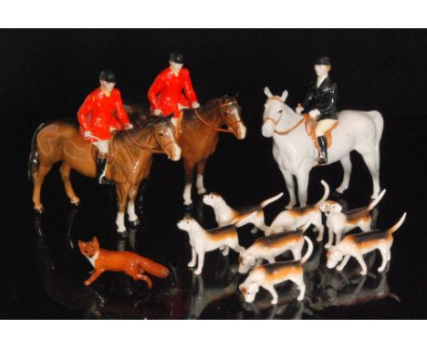 A Beswick hunting group comprising two Huntsman model 1501, a Huntswoman model 1730 on a grey horse, also seven hounds and a 