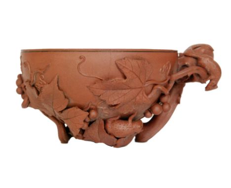 A Chinese Yixing cup formed as a libation cup with moulded and applied grape and vines, impressed seal mark, diameter 9.5cm, 