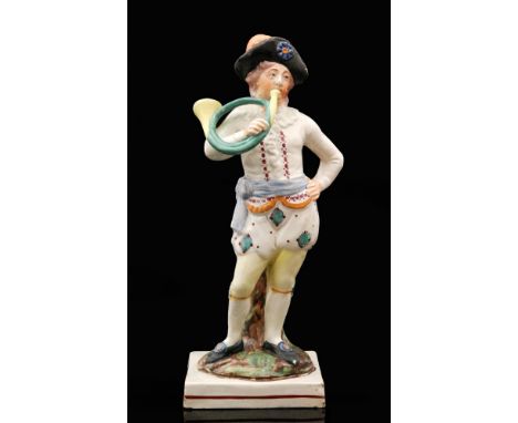 A 19th Century Staffordshire pearlware figure modelled as a standing male figure playing the French horn, all to a square bas