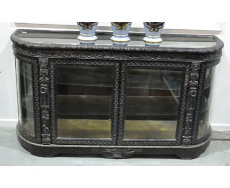 A late Victorian Renaissance style carved oak ebonised demi-lune display cabinet, the fitted glass shelf interior enclosed by