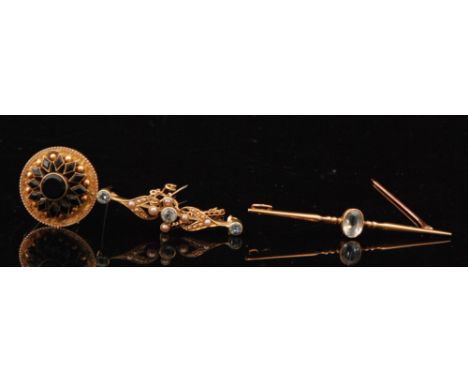 An Edwardian aquamarine and seed pearl pin brooch, three collar set aquamarines spaced by seed pearl foliate sprays, together