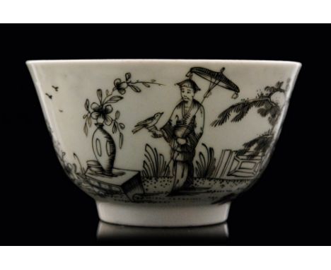 An 18th Century Worcester Chinoiserie tea bowl black pencil decorated with a figure holding a parasol and a bird in his hand 