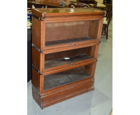 An early 20th Century Globe Wernicke oak three tier bookcase on a plinth base, width 86cm