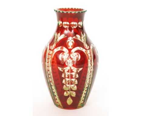 An early 20th Century uranium glass vase of shouldered ovoid form, cased in ruby and flash cut with a repeat scroll pattern b