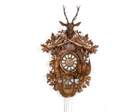 A large late 19th Century Black Forest carved cuckoo clock, the case mounted with dead game below a double door and stag abov