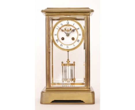 An early 20th Century brass mantle clock with open anchor escapement, the mercury suspended pendulum enclosed by glazed bevel