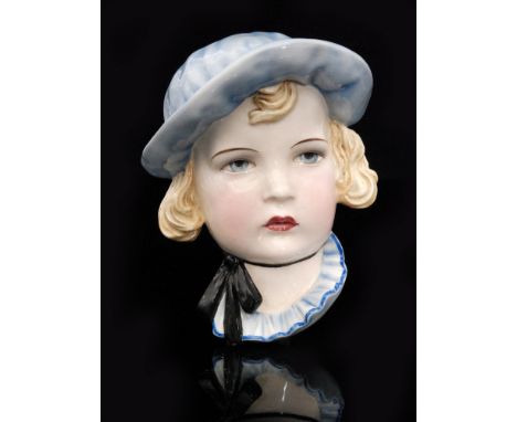 A 1930s Goldscheider Shirley Temple face mask designed by Stephan Dakon, model 7409, impressed and printed marks, length 21cm