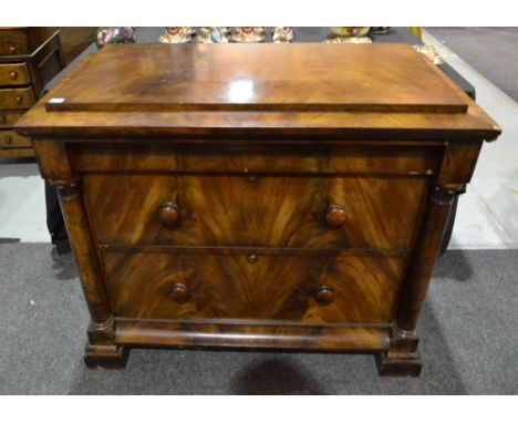 A Victorian mahogany caddy top chest of two drawers below a secret frieze drawer, flanked by carved capital pilasters on a pl