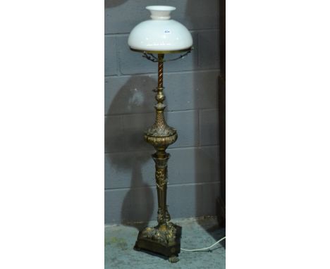 An early 20th Century copper embossed adjustable standard lamp and shade on acanthus stylised column and shaped mahogany plat