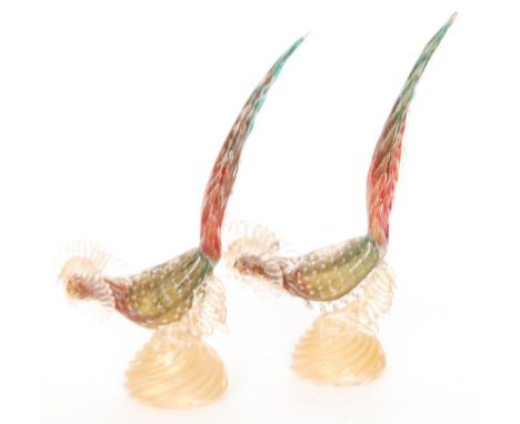 A pair of 20th Century Murano glass fighting birds in emerald graduating to ruby with controlled air bubbles to the body and 