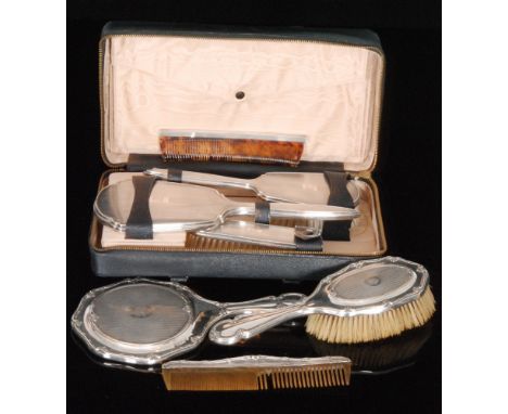 A hallmarked silver three piece dressing table set composed of brush, comb and mirror, Birmingham 1912, together with another