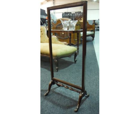 An early 20th Century mahogany fire screen by Waring and Gillow, with a later replaced glazed panel above a turned stretcher 