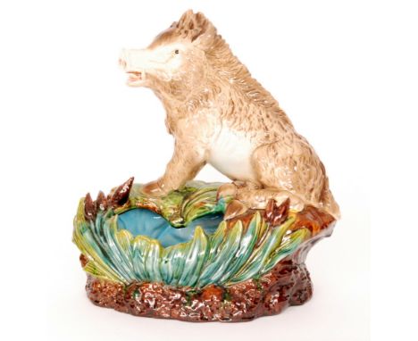 A large 19th Century majolica table centre planter modelled as a wild boar sat on a grassy bank with brown flowers, impressed