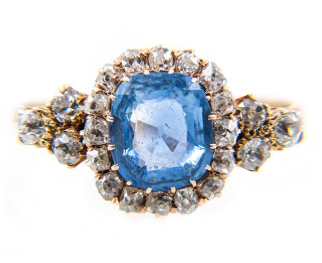 A sapphire and diamond rectangular cluster ring, one rectangular cushion shaped sapphire 9mm x 8.2mm, surrounded by sixteen o