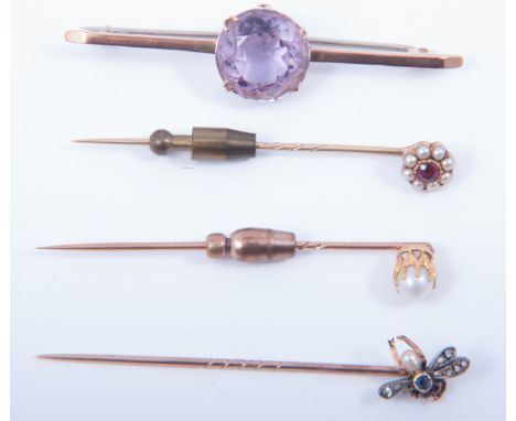 Three stick pins and an amethyst bar brooch, the 65mm long bar brooch having a 5mm circular faceted amethyst to centre, the s