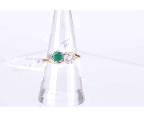 An 18 ct gold emerald and 25 point diamond cross over ring, size R, 4.2g