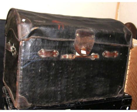 An antique dome top black leather travelling trunk