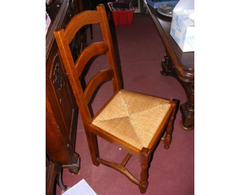 A set of eight oak ladder back chairs with rush lift-out seats