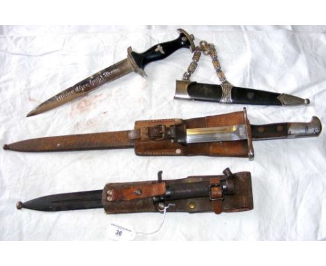 An old bayonet with scabbard, together with two other daggers