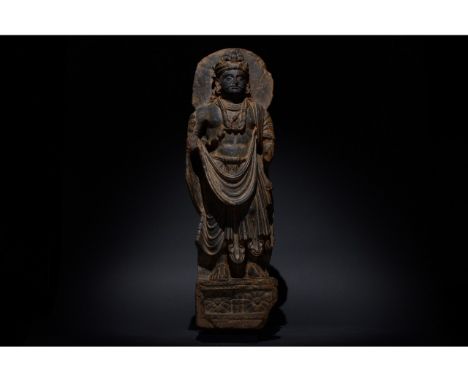 100-300 AD. Gandharan. Schist figure of a bodhisattva, backed by a halo, who stands, gazing serenely into the distance. He is