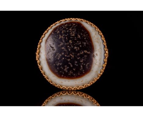 A round shape cabochon agate chalcedony gemstone, set in a gold triangular-edge frame decorated with repetitive triangle shap