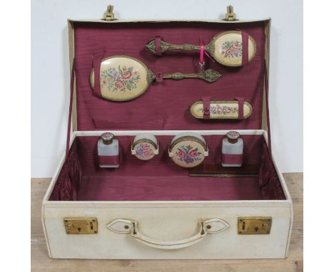 A vintage vanity case complete with brushes, mirror, bottles and powder jars. 