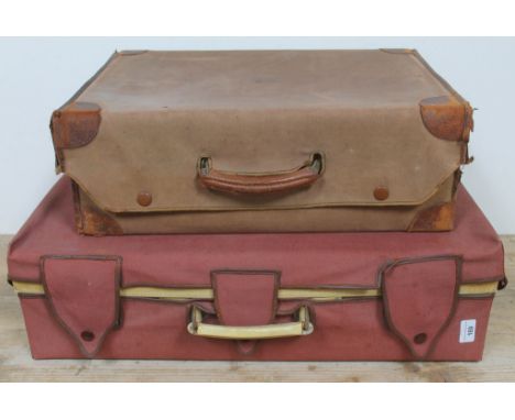 Two vintage leather suitcases, each with protective covers. 
